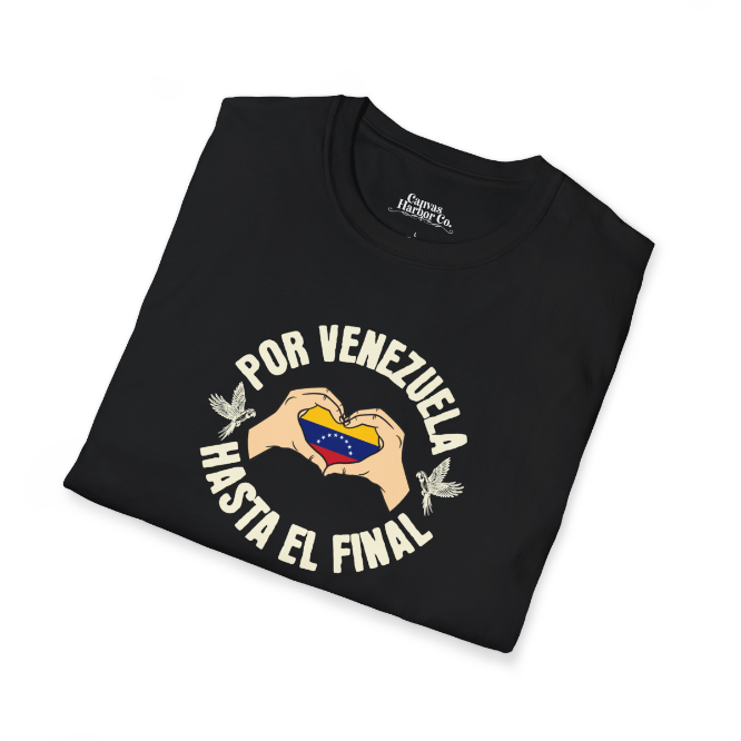 A folded black unisex t-shirt featuring a Venezuelan flag inside heart-shaped hands, the text "Por Venezuela Hasta El Final", and a pair of macaws on either side.