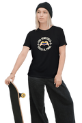 A blonde woman is wearing a black unisex t-shirt featuring a Venezuelan flag inside heart-shaped hands, the text "Por Venezuela Hasta El Final", and a pair of macaws on either side. She's holding a skateboard.