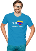 A man is wearing a blue unisex t-shirt featuring a heart-shaped Venezuelan flag, the word "Yo" on the left, and the text "¡Hasta El Final!" reading below. He is smiling with glasses.