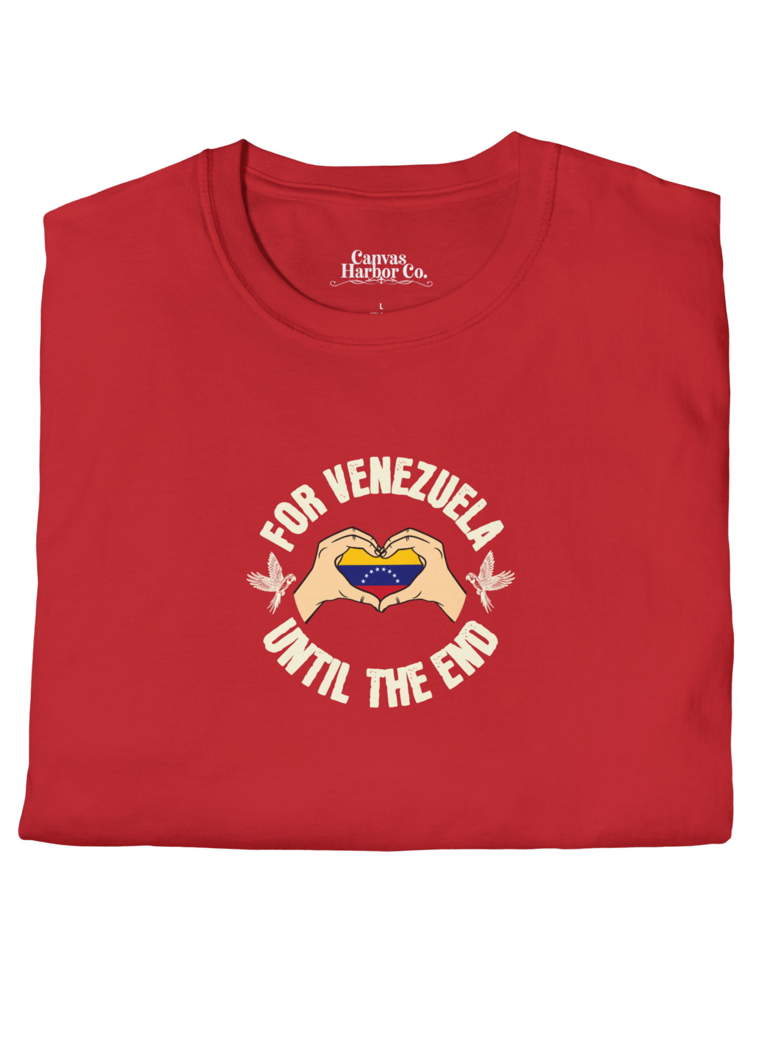Red folded T-shirt featuring the Venezuelan flag inside heart-shaped hands, the text "FOR VENEZUELA UNTIL THE END" around it, and one macaw on each side.