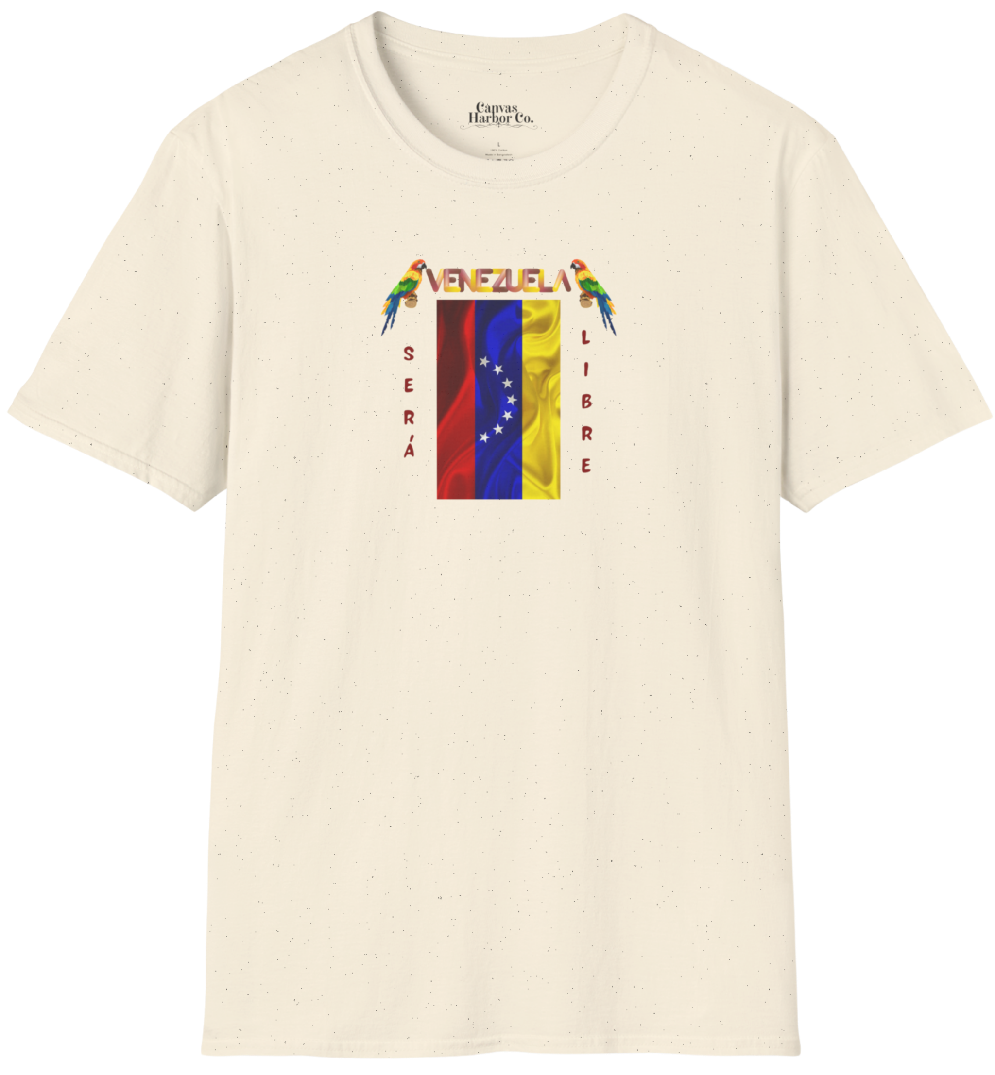 Franela color crema con la bandera venezolana de 7 estrellas, el nombre VENEZUELA arriba y una guacamaya a cada lado. Las palabras SERÁ y LIBRE se ubican verticalmente junto a la bandera.