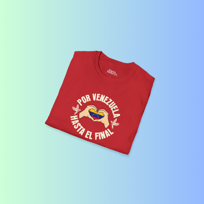 A folded red unisex t-shirt featuring a Venezuelan flag inside heart-shaped hands, the text "Por Venezuela Hasta El Final", and a pair of macaws on either side.
