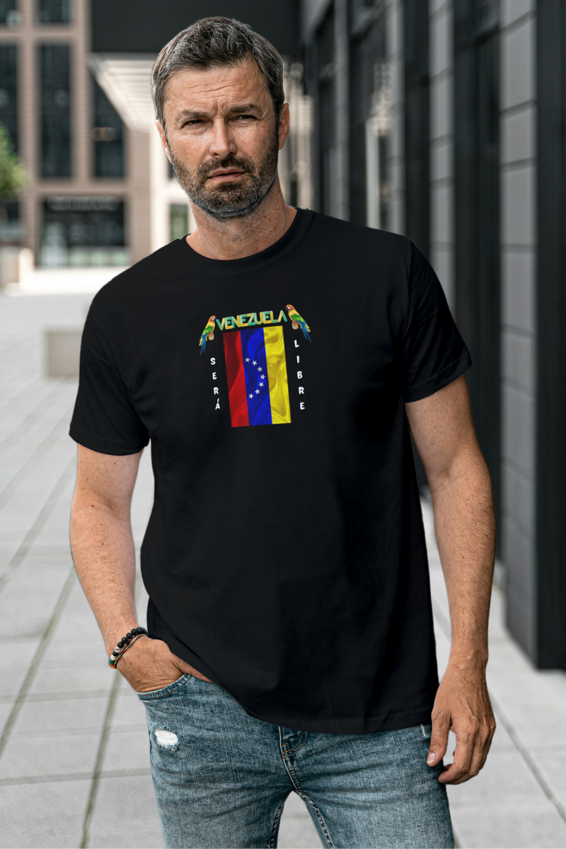 Un hombre con barba viste una franela color negro con la bandera venezolana de 7 estrellas, el nombre VENEZUELA arriba y una guacamaya a cada lado. Las palabras SERÁ y LIBRE se ubican verticalmente junto a la bandera.
Él está de pie, frente a la entrada de un edificio. 