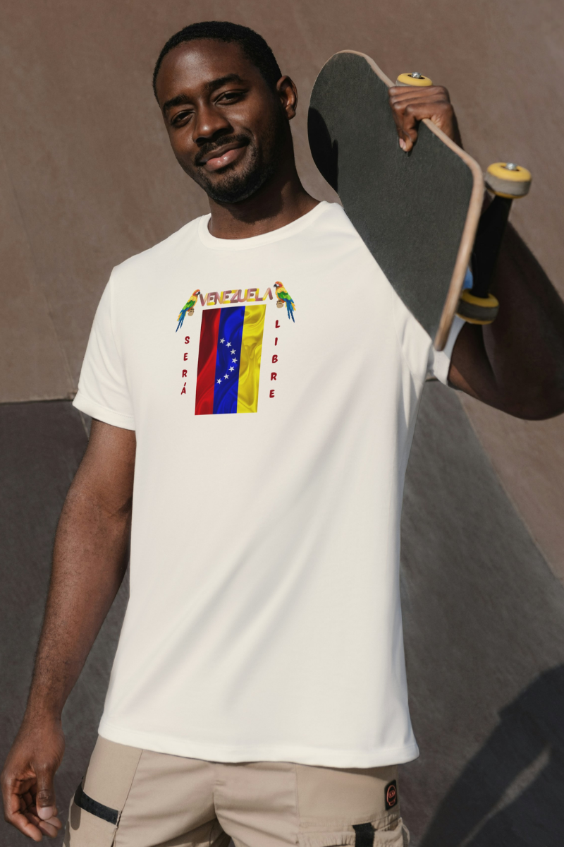 Un hombre afroamericano viste una franela color crema con la bandera venezolana de 7 estrellas, el nombre VENEZUELA arriba y una guacamaya a cada lado. Las palabras SERÁ y LIBRE se ubican verticalmente junto a la bandera.
Él está parado, sosteniendo una patineta sobre su hombro izquierdo. 