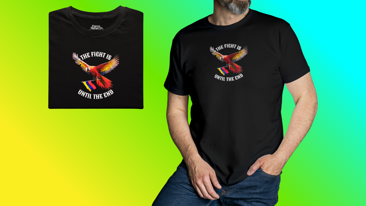 Black folded T-shirt featuring an image of a macaw and the Venezuelan flag. The text "THE FIGHT IS UNTIL THE END" surrounds the bird.
On the right, a man wears the T-shirt, He’s standing, with his left hand in the pocket of his pants.