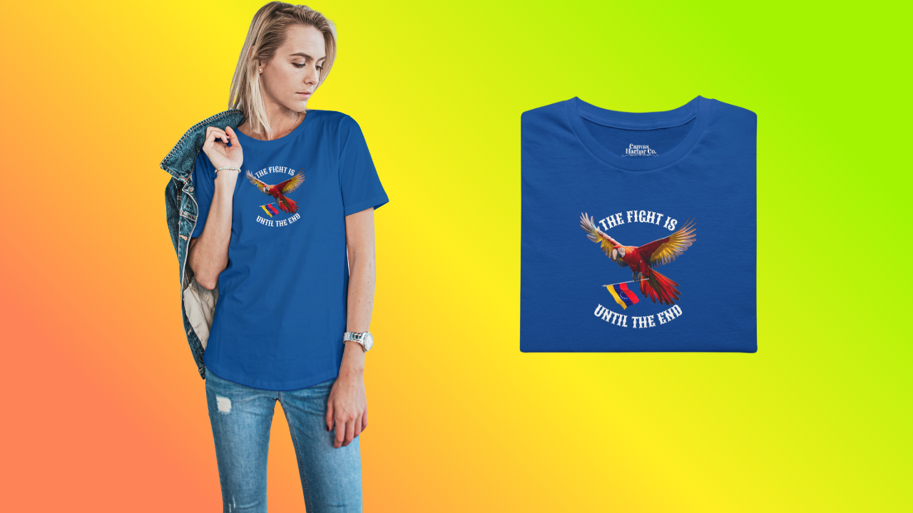 Blue folded T-shirt featuring an image of a macaw and the Venezuelan flag. The text "THE FIGHT IS UNTIL THE END" surrounds the bird.
On the left, a young blonde woman wears the T-shirt. She’s standing, looking down to her left.