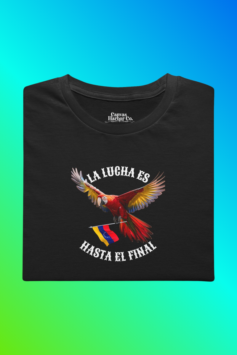 Franela negra, doblada, con la imagen de un guacamayo con la bandera venezolana. La frase "LA LUCHA ES HASTA EL FINAL" rodea al ave.