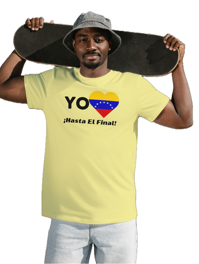 A man is wearing a yellow unisex t-shirt featuring a heart-shaped Venezuelan flag, the word "Yo" on the left, and the text "¡Hasta El Final!" reading below. He is holding a skateboard behind his neck.